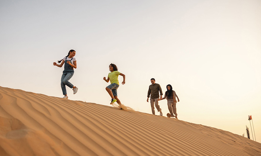 Sandboarding during morning desert safari in Dubai