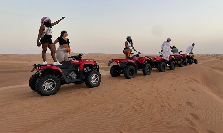 Guest riding Kymco MXU 250 CC quad bike over Dubai dunes